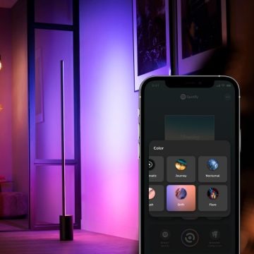 Smart floor lamp with mobile device displaying Hue scene gallery in Hue app
