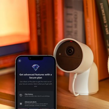 A white Hue Secure camera and the Hue app showing advanced secure features available with plus plan subscription.