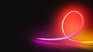 An OmniGlow strip light glowing in pink, red and yellow light against a black background. 