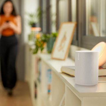 A Sonos smart speaker placed on a bedside table and Philip Hue smart lamps and spotlights illuminating the space