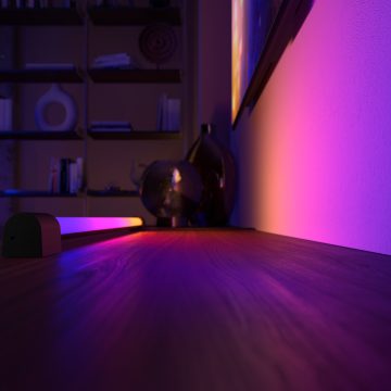 A Hue gradient light tube washing a wall with a blend of blue, pink, purple, and yellow tones of smart light.