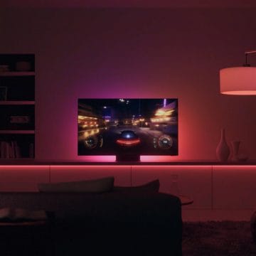 TV playing a racing game in living room with pink and red lights