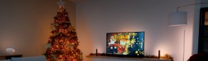 Philips Hue smart Christmas lights create a festive scene with a decorated tree and TV with synced Play light bars.