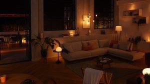 Living room with a sectional sofa illuminated by warm smart lighting, creating a soft ambient glow suitable for evening relaxation.