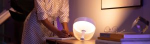 Couple smiling with Philips Hue Signe table lamp on in background testing