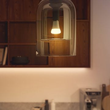 A Hue smart bulb glowing in warm white tunable light.
