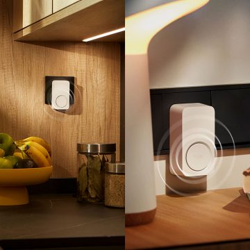 A Hue Smart Chime plugged into a wall socket in a kitchen sounding an alert. 