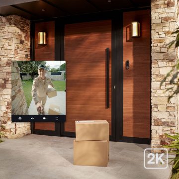 A front door with a delivery of boxes and an inset photo showing the delivery person via a Hue video doorbell.
