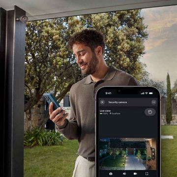 A person installing a wired doorbell using a drill.