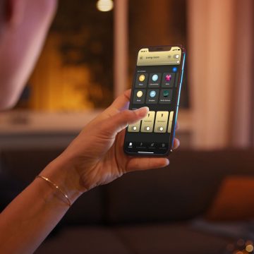 A Hue smart light user navigating the Hue app on a smart phone