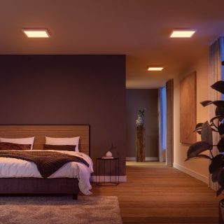 Ceiling-mounted square smart lights illuminate a bedroom and hallway, casting adjustable light onto walls and floor surfaces.