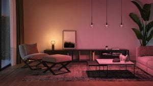 Living room with soft ambient lighting, modern furniture, pendant lights, and a warm glow from a table lamp on a sideboard.