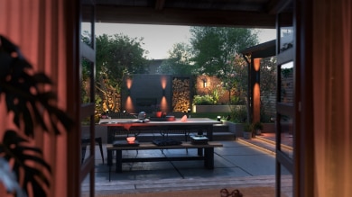 A backyard and patio are beautifully lit in cozy tones of smart light available in the outdoor smart lighting sale.