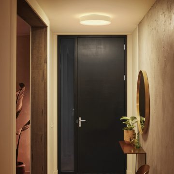 Ronde plafondlamp ingesteld op helder wit licht in een gang