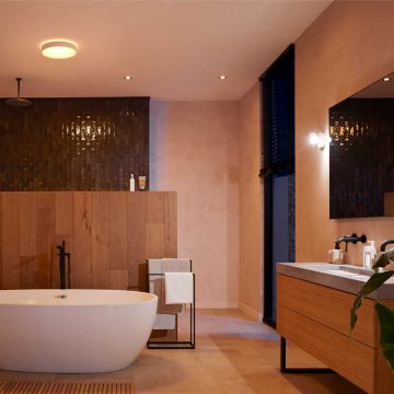 Ronde plafondlamp in een moderne badkamer met vrijstaand bad