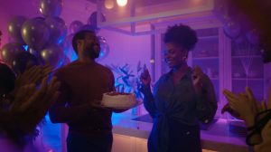 Gruppe mennesker feirer med glede på en livlig fest under levende stemningsbelysning som forsterker den festlige og energiske atmosfæren.