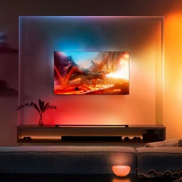 Televisor Samsung pendurado na parede da sala de estar rodeado de luzes coloridas 