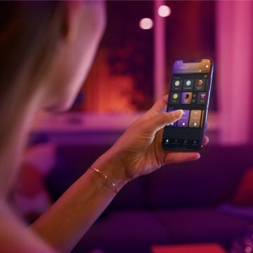 Mão com um dispositivo móvel a mostrar a Hue app